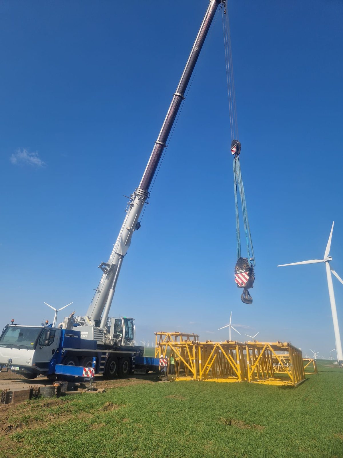 Automacara Liebherr cu brațul ridicat pe șantier